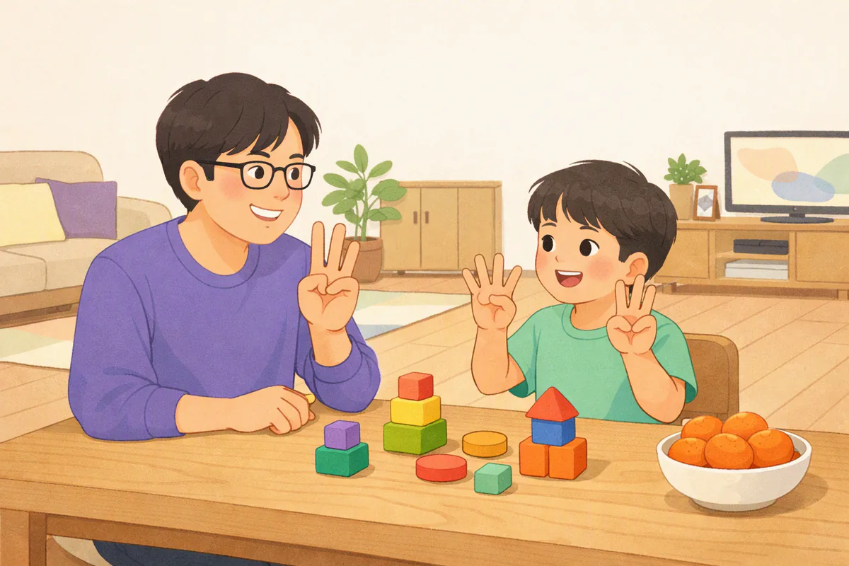 식탁에서 아빠와 아이가 손가락을 펴서 숫자를 세며 웃고, 탁자 위에 블록과 귤 한 그릇이 놓여 있다